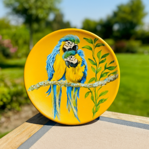 Hand-painted 6-inch terracotta plate featuring a blue and yellow macaw bird on a yellow background, decorative handmade home décor