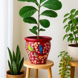 Hand-painted terracotta planter featuring colourful birds and blossom motifs on a deep red background