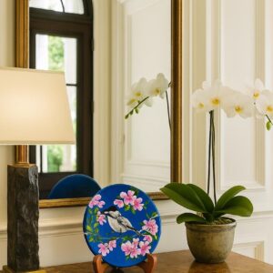 Hand-painted decorative plate featuring a bird among pink sakura blossoms on a blue background